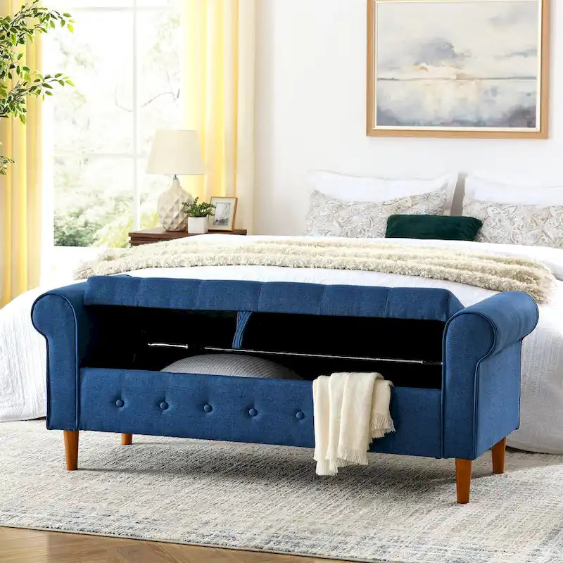 Banc de rangement capitonné en tissu bleu avec accoudoirs roulés et pieds en bois